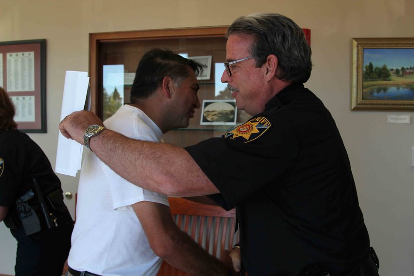 John Castillo goes in to hug Sheriff Tony Spurlcok before a July 16 Board of County Commissioners work session.